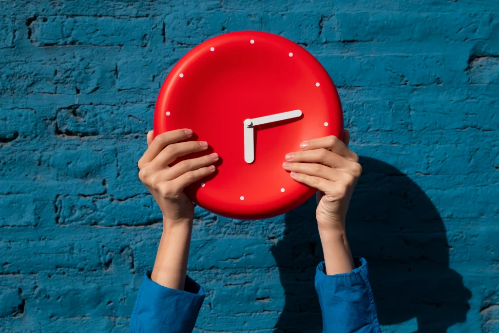 manos sosteniendo bodegon de reloj de pared